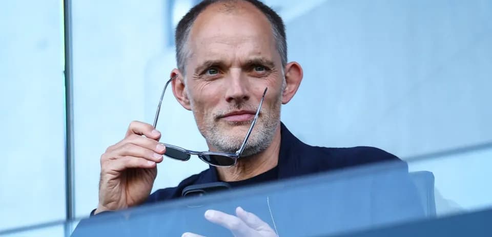 Hombre sosteniendo gafas en un palco deportivo