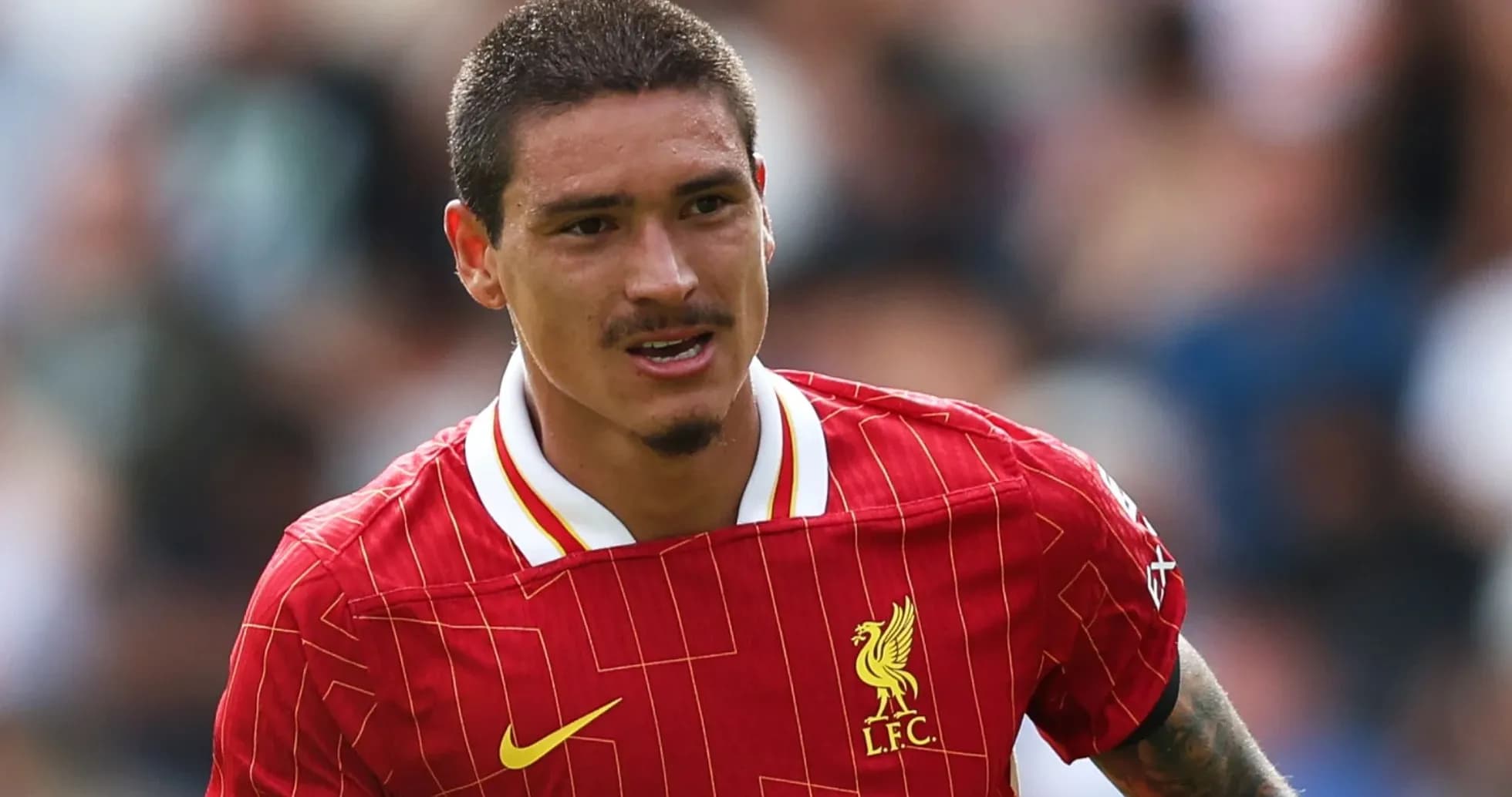 Jugador de Liverpool corriendo en campo de fútbol