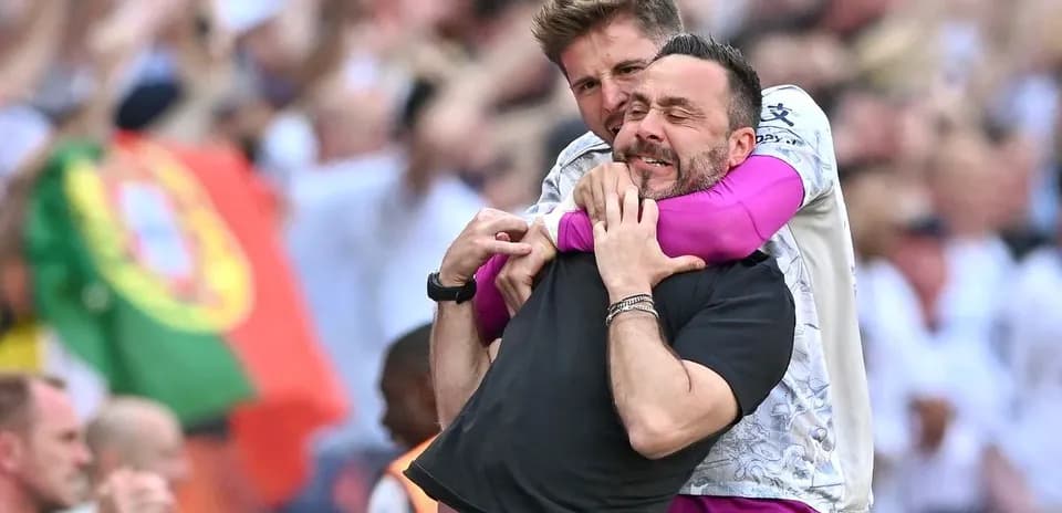 Entrenador y jugador celebrando en el campo