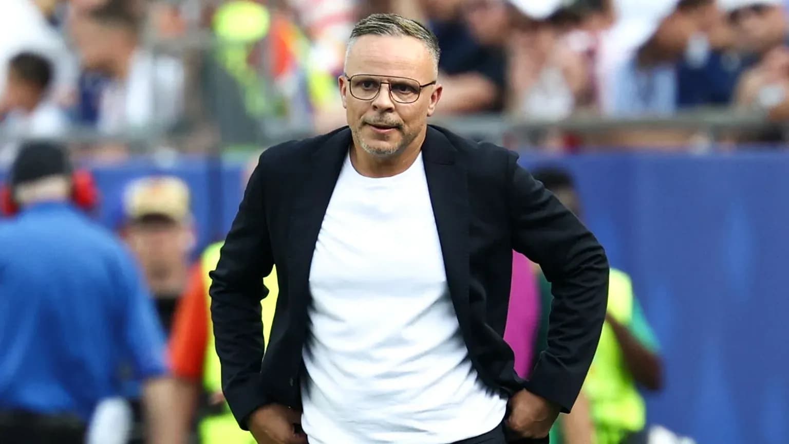 Entrenador caminando en el área técnica del partido