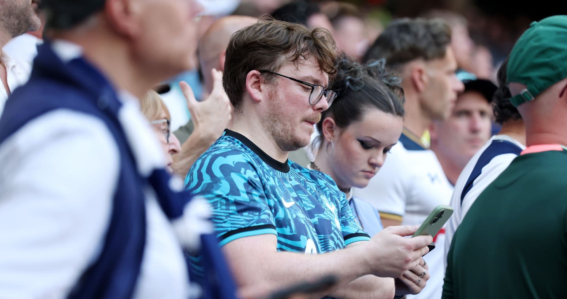 Espectadores en el estadio usando sus teléfonos móviles