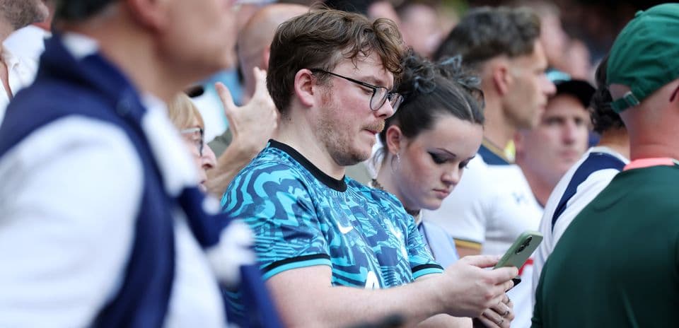 Espectadores en el estadio usando sus teléfonos móviles