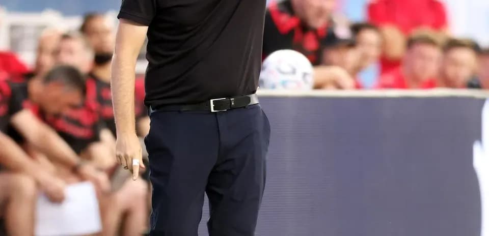 Entrenador dirigiendo instrucciones desde la línea de banda