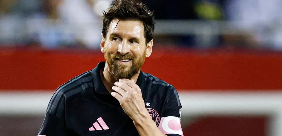 Jugador de fútbol con camiseta negra sonriendo durante el partido