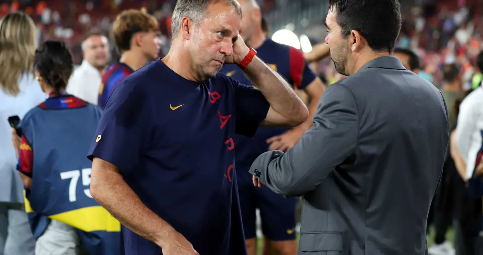 Entrenador conversando con otro hombre en el campo