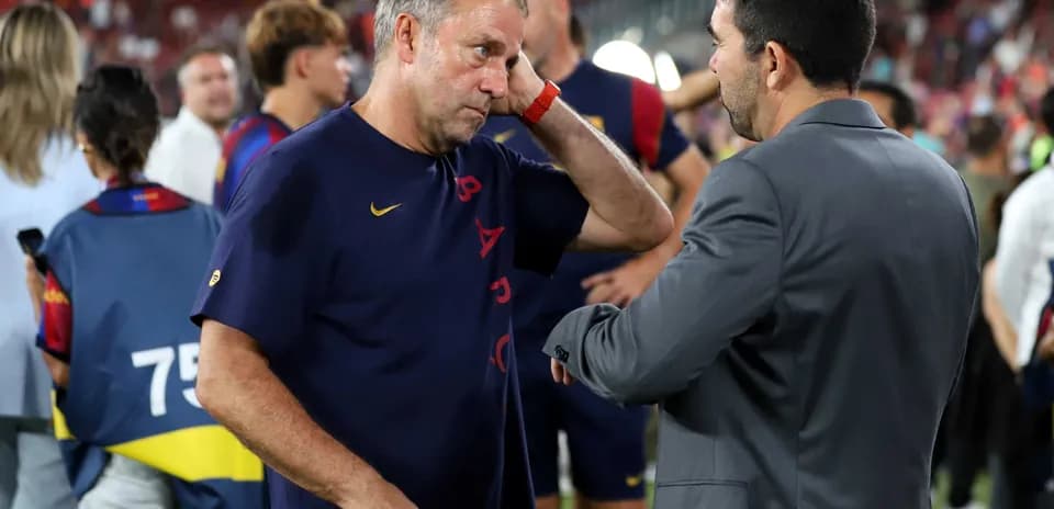 Entrenador conversando con otro hombre en el campo