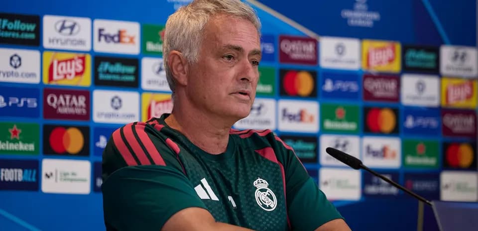 Entrenador en rueda de prensa con fondo de patrocinadores
