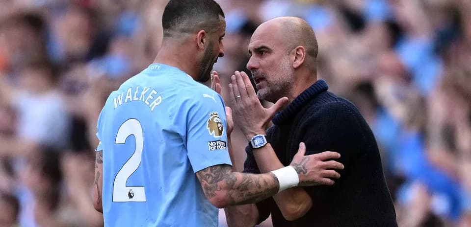 Kyle Walker conversando con Pep Guardiola en el campo