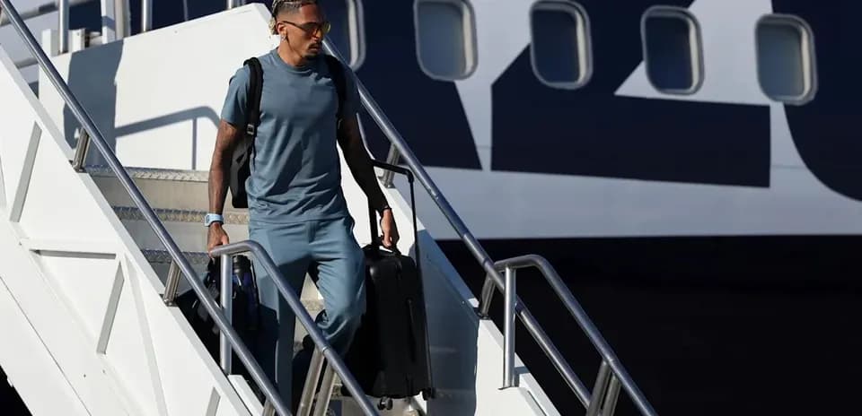 Jugador bajando de un avión con maleta