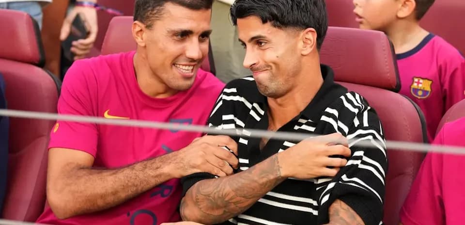 Dos jugadores sentados conversando en un estadio