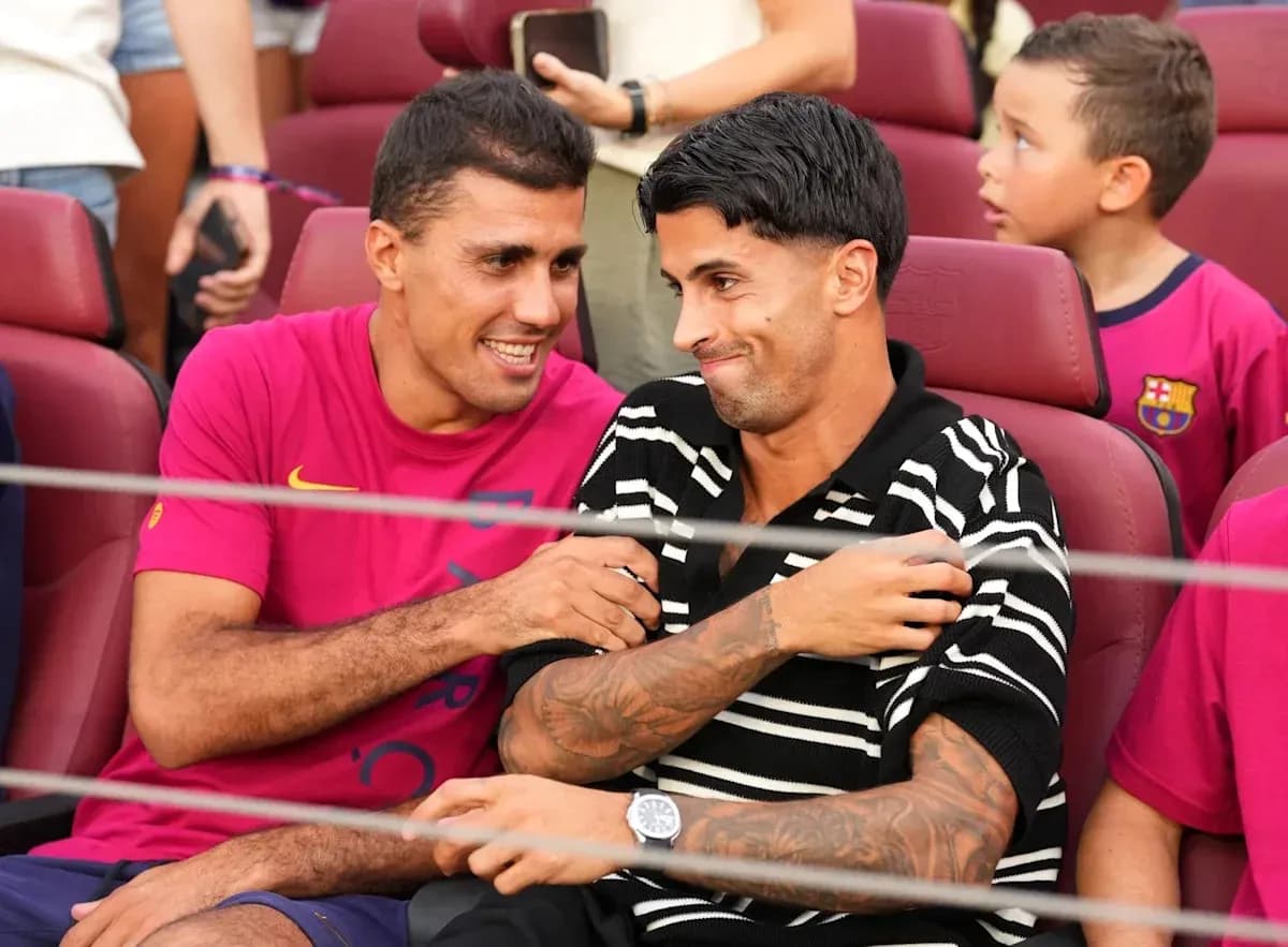Dos jugadores sentados conversando en un estadio