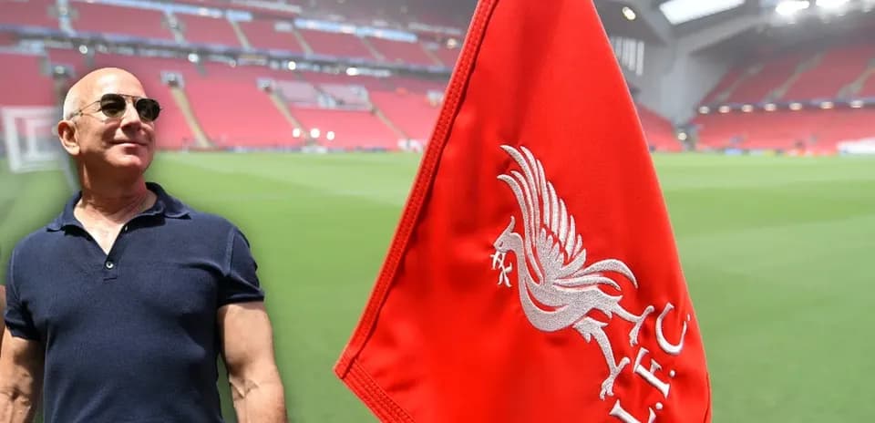Hombre junto a bandera de Liverpool en el estadio