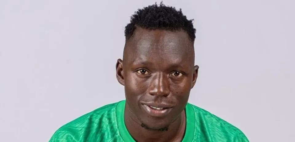 Jugador de fútbol con camiseta verde posando para foto