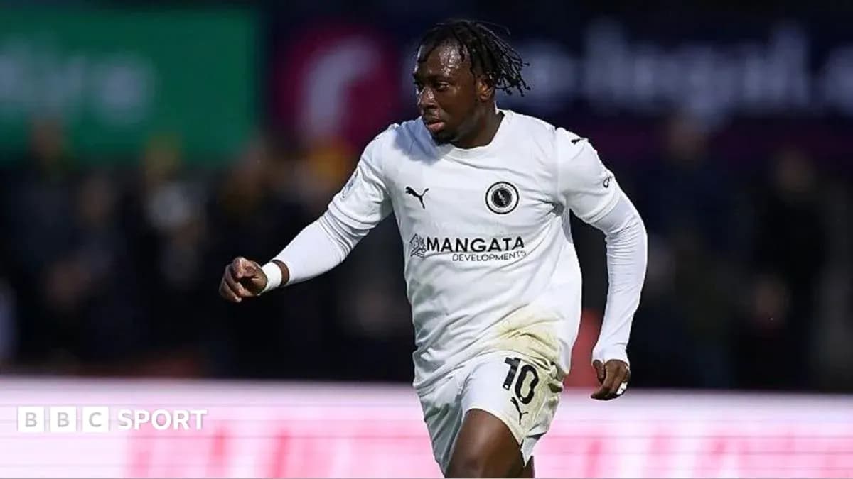 Jugador corriendo con camiseta blanca durante partido