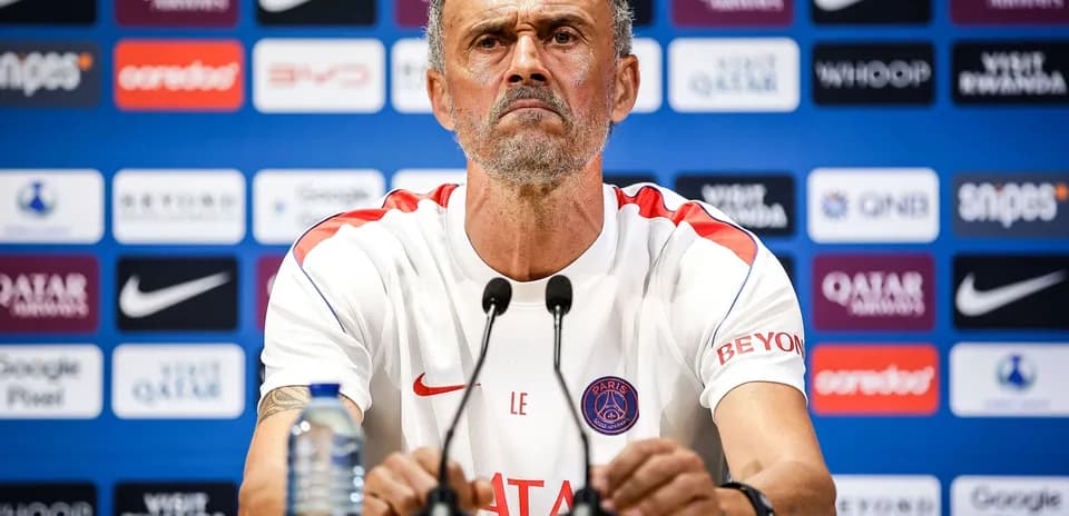 Entrenador en conferencia de prensa con logos de patrocinadores