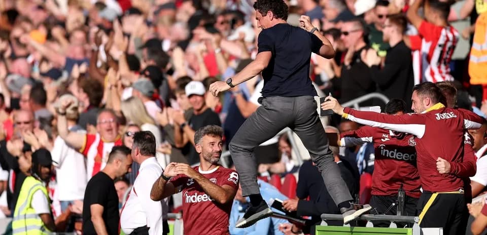 Entrenador celebrando con afición tras gol