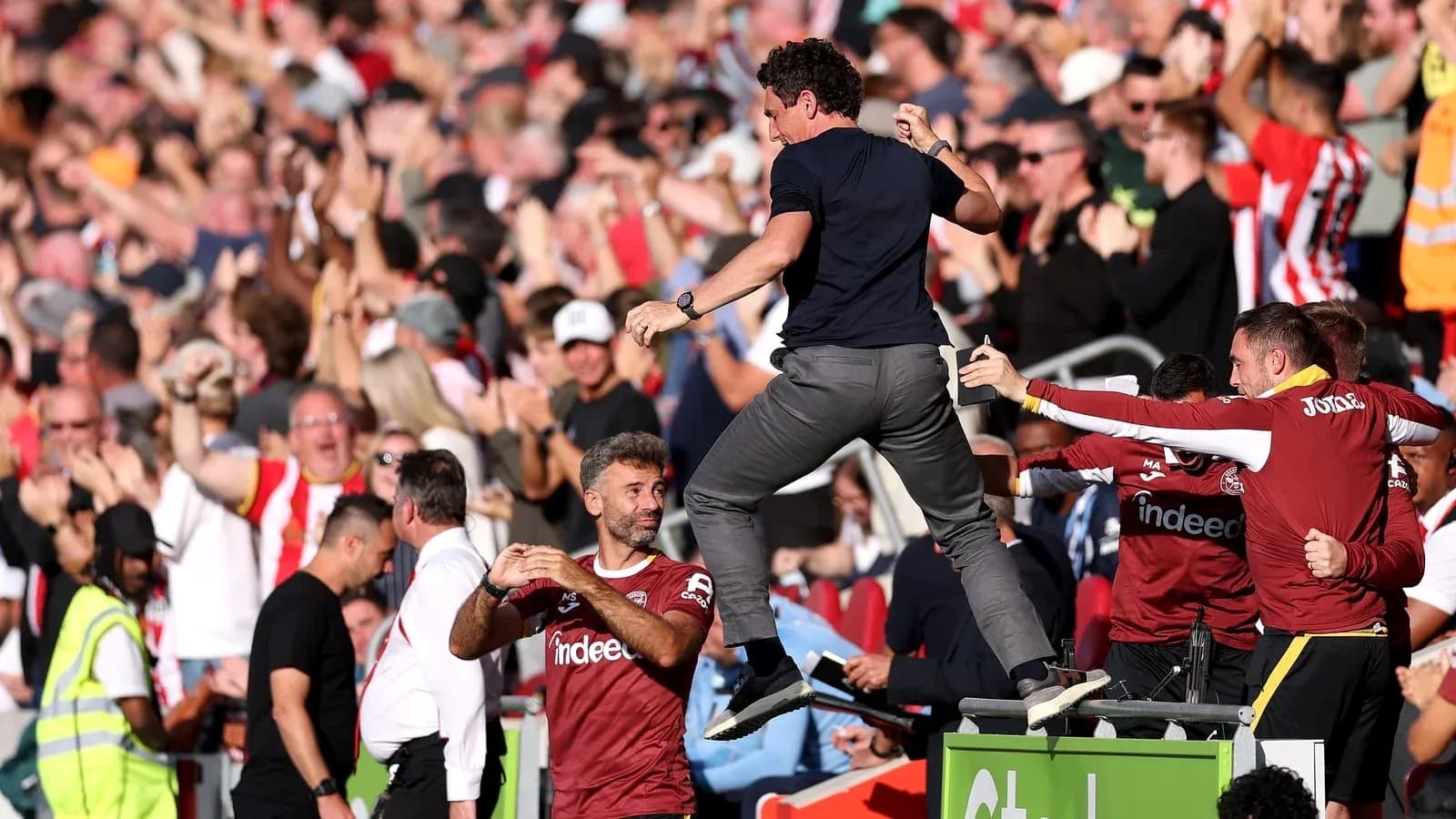 Entrenador celebrando con afición tras gol