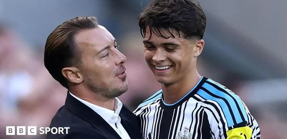 Entrenador y jugador sonriendo en el campo
