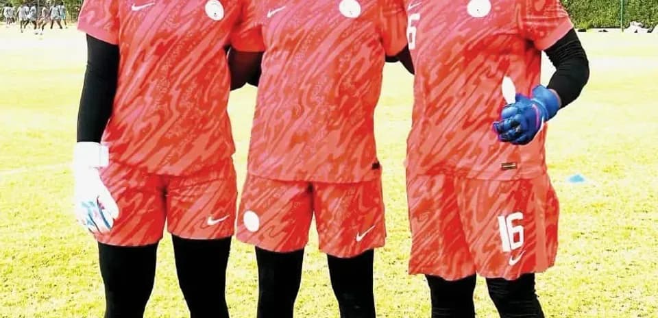 Tres jugadoras de fútbol en uniforme rojo posando