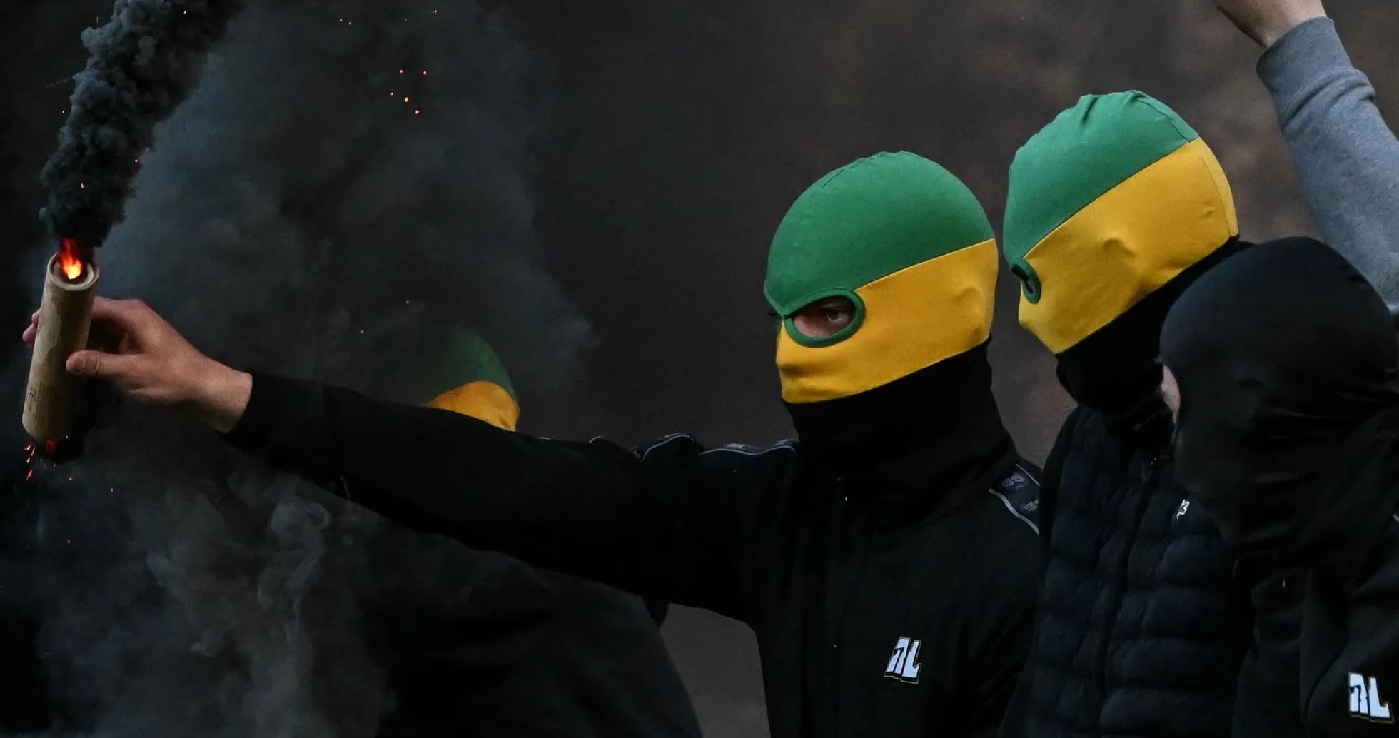 Person lanzando un objeto humeante en manifestación
