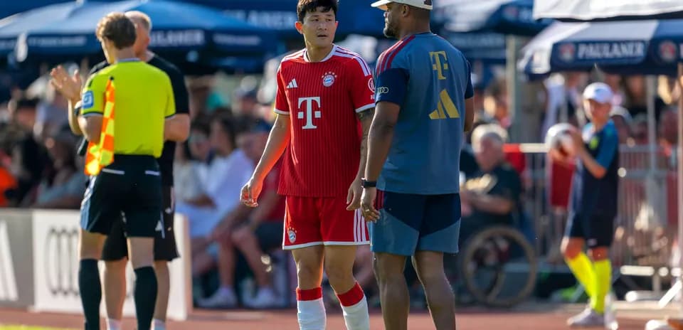 Jugador de Bayern conversando con entrenador durante partido