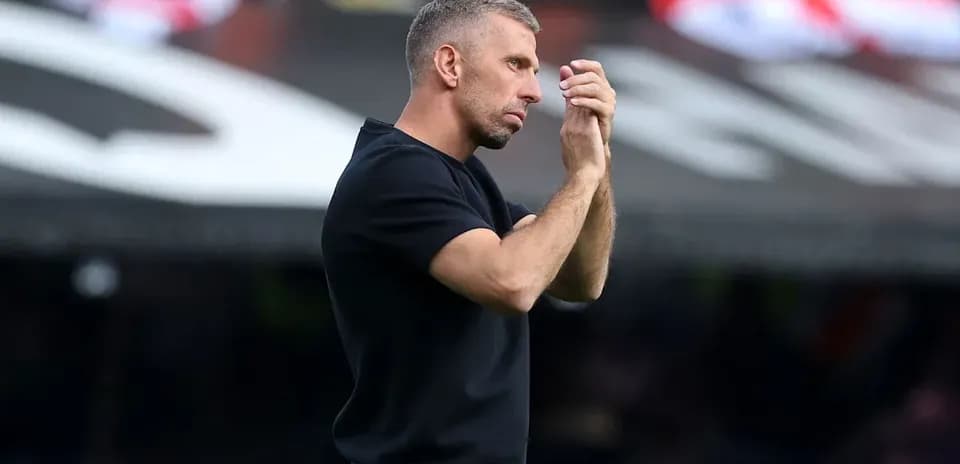Entrenador gesticulando durante un partido de fútbol