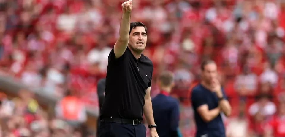Entrenador señalando desde la línea de banda