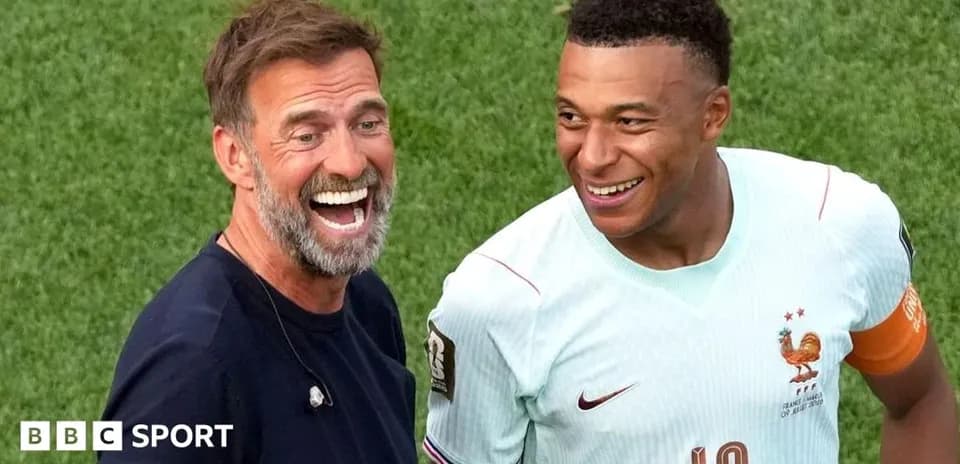 Entrenador y jugador riendo en el campo de fútbol