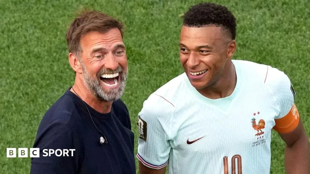 Entrenador y jugador riendo en el campo de fútbol