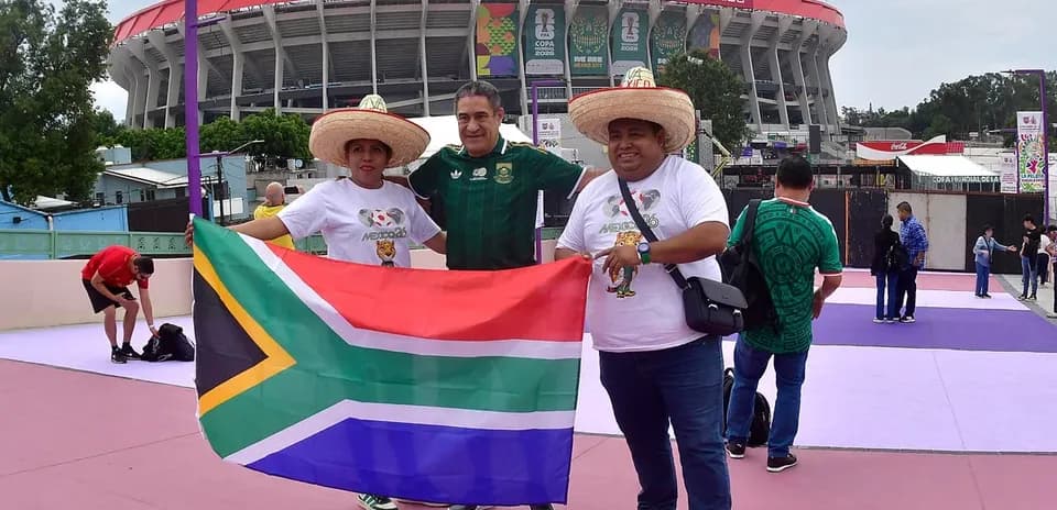 Aficionados sosteniendo una bandera sudafricana en el estadio