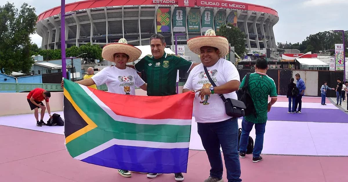 Aficionados sosteniendo una bandera sudafricana en el estadio