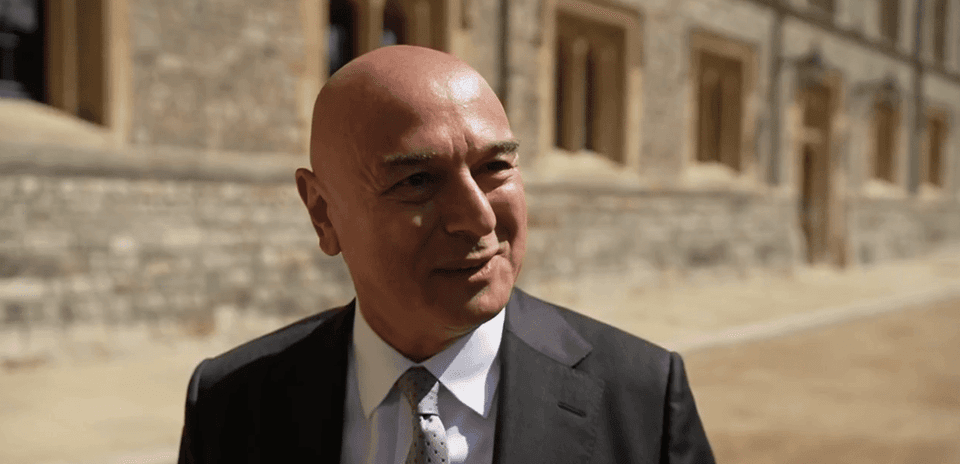 Hombre con traje sonriendo en exterior de edificio