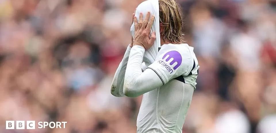Jugador cubriendo su rostro con camiseta en el campo