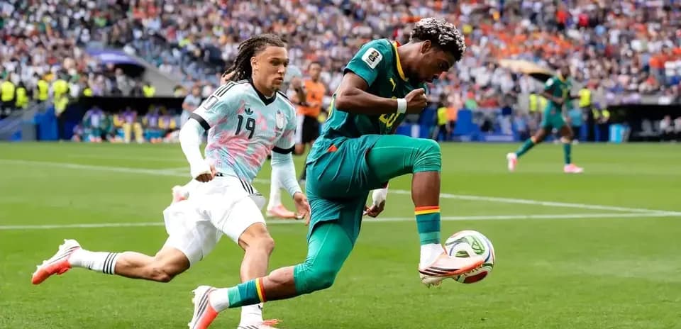 Jugador de Camerún driblando a oponente en partido