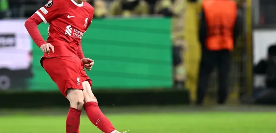 Jugador de Liverpool golpeando el balón en el campo