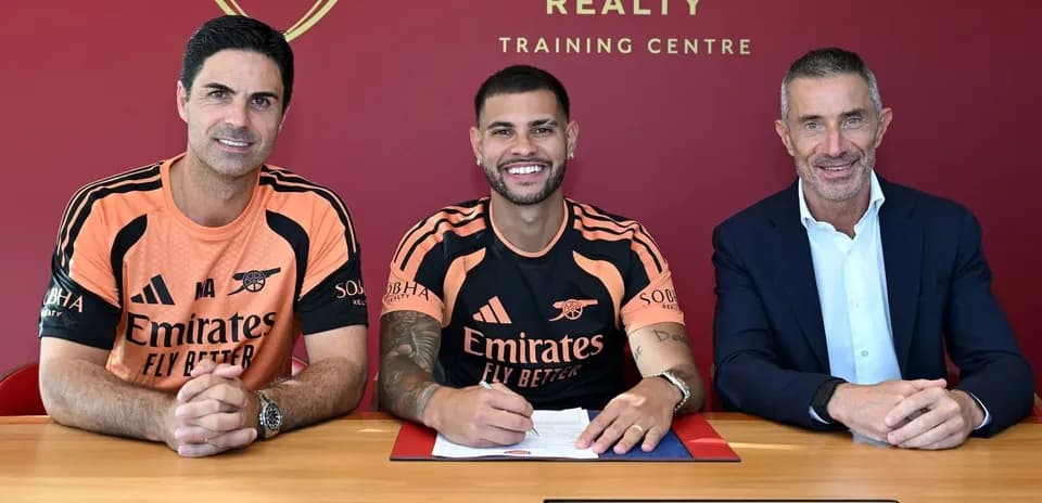 Jugador firmando contrato con directivos en centro de entrenamiento
