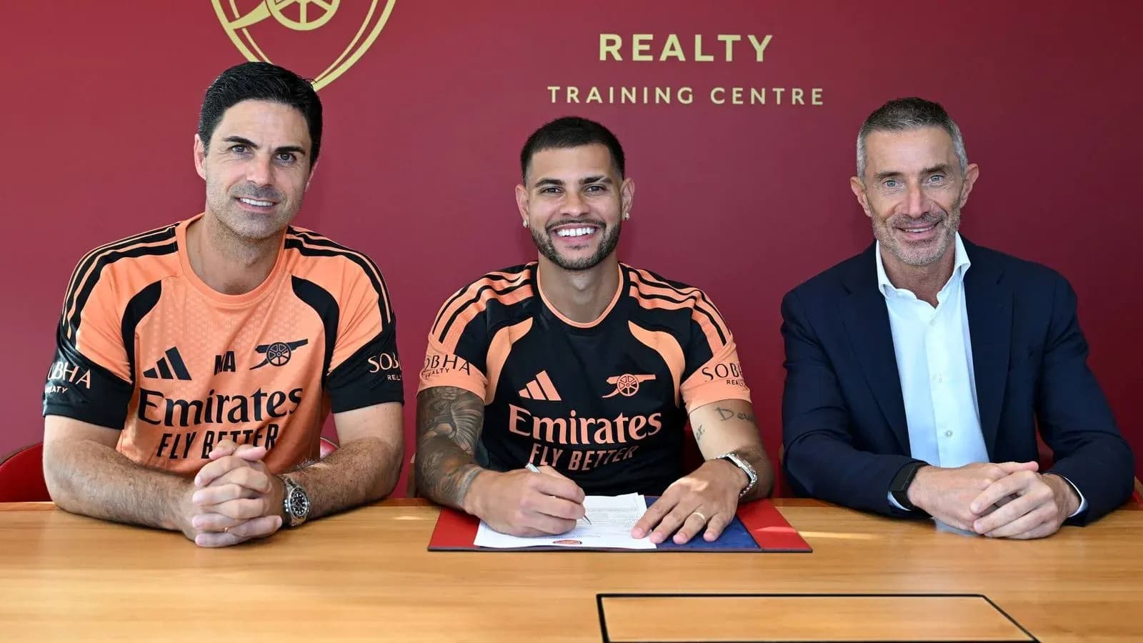 Jugador firmando contrato con directivos en centro de entrenamiento