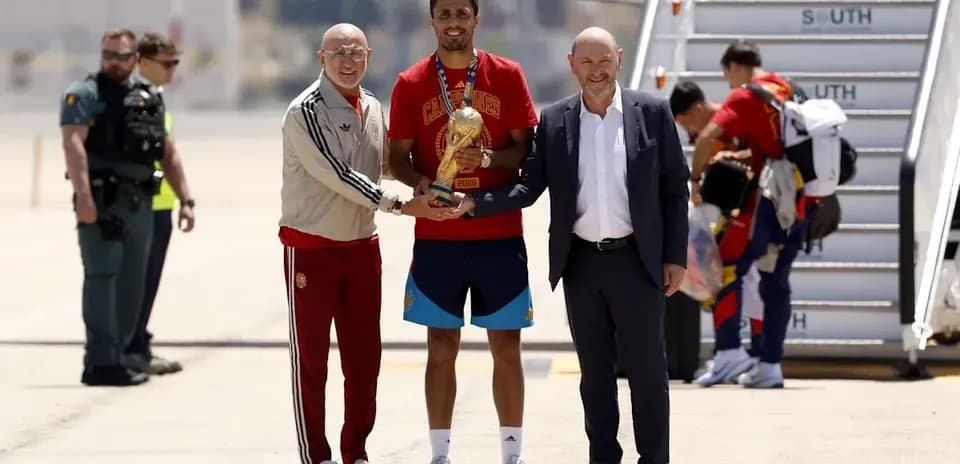 Jugadores y directivos celebrando un trofeo en el aeropuerto