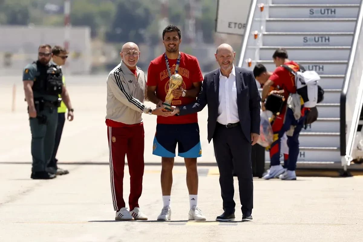Jugadores y directivos celebrando un trofeo en el aeropuerto