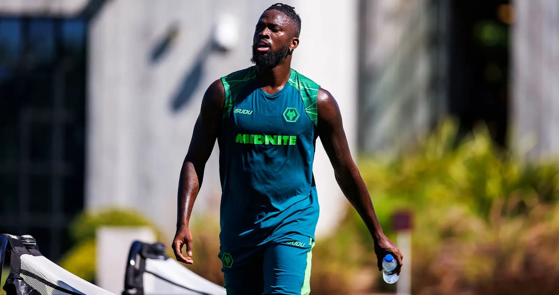 Jugador caminando con botella de agua en entrenamiento