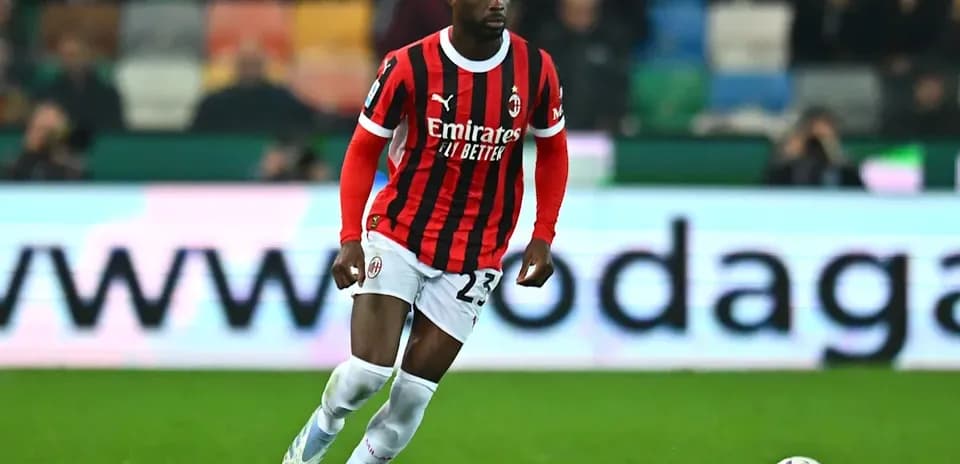 Jugador de AC Milan corriendo con el balón en el campo