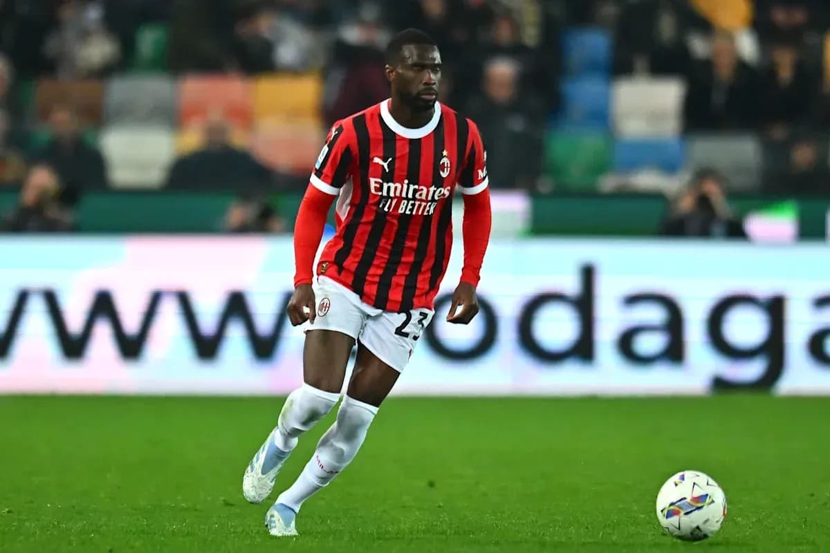 Jugador de AC Milan corriendo con el balón en el campo