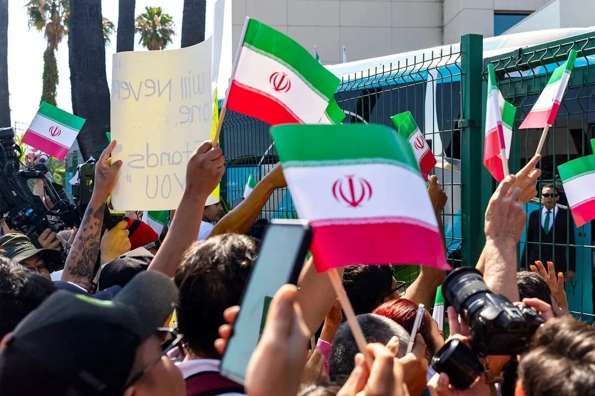 Multitud sosteniendo banderas de Irán durante una protesta