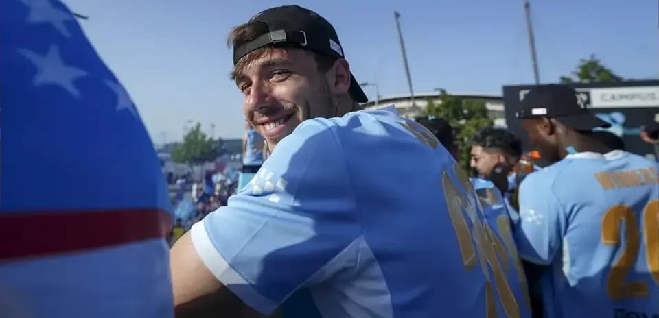 Jugador sonriendo en evento con equipo de fútbol