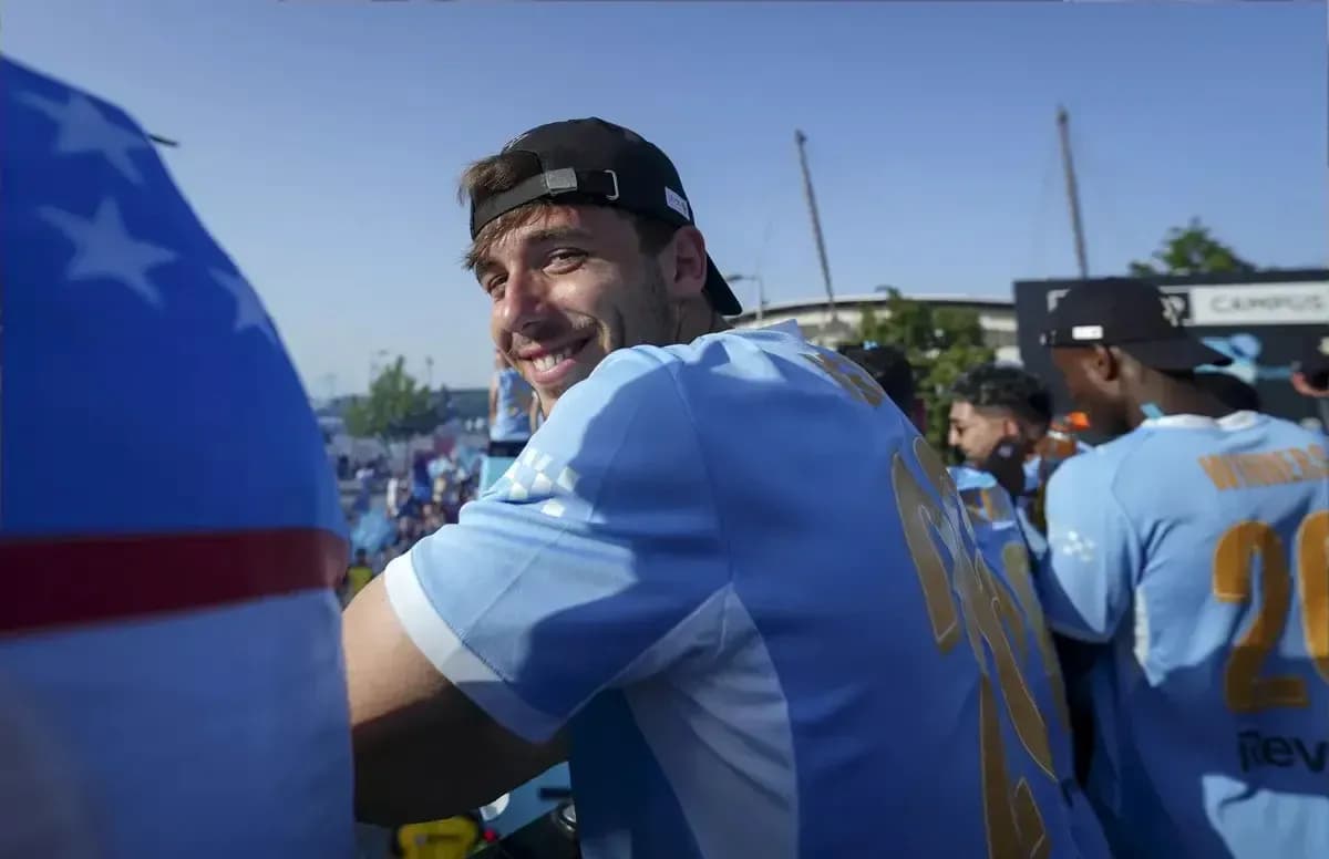 Jugador sonriendo en evento con equipo de fútbol