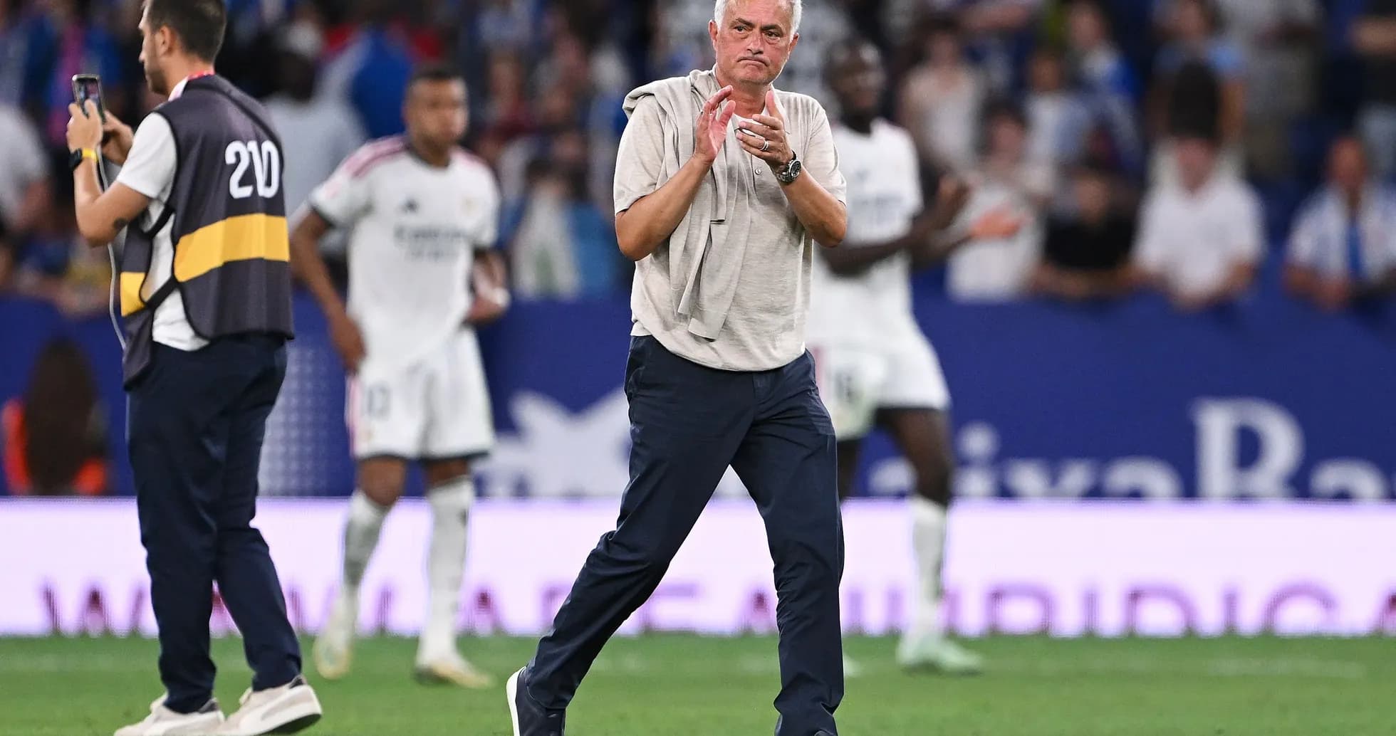 Entrenador aplaudiendo en el campo durante partido