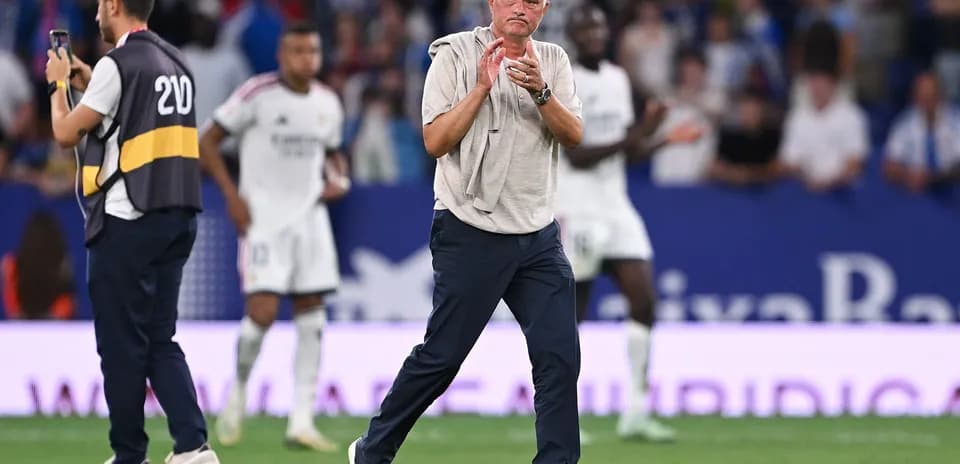 Entrenador aplaudiendo en el campo durante partido