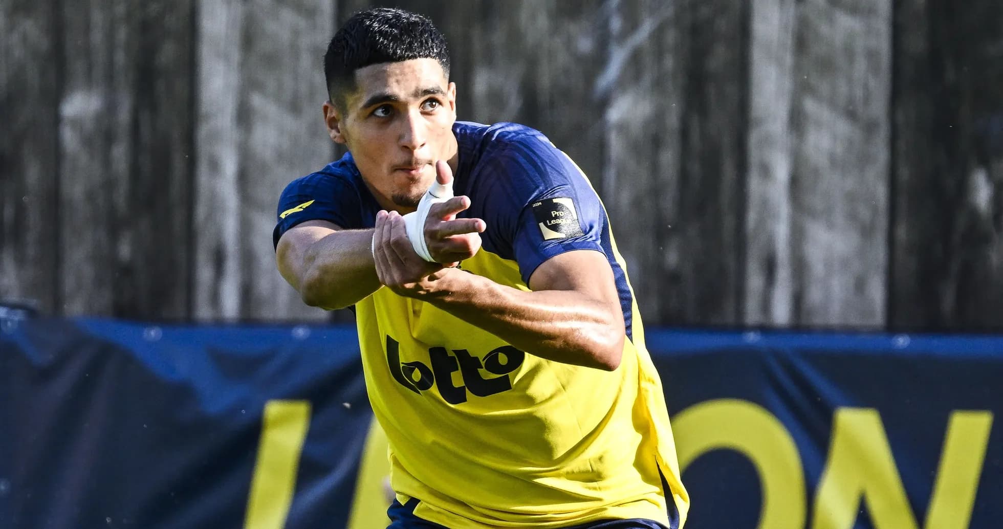 Jugador de fútbol entrenando con balón en mano