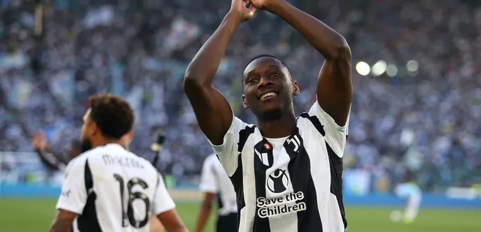 Jugador celebrando en el campo con aficionados de fondo