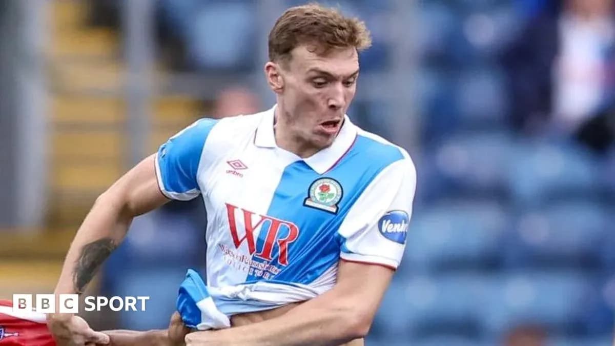 Jugador de Blackburn Rovers ajustando su camiseta durante el partido